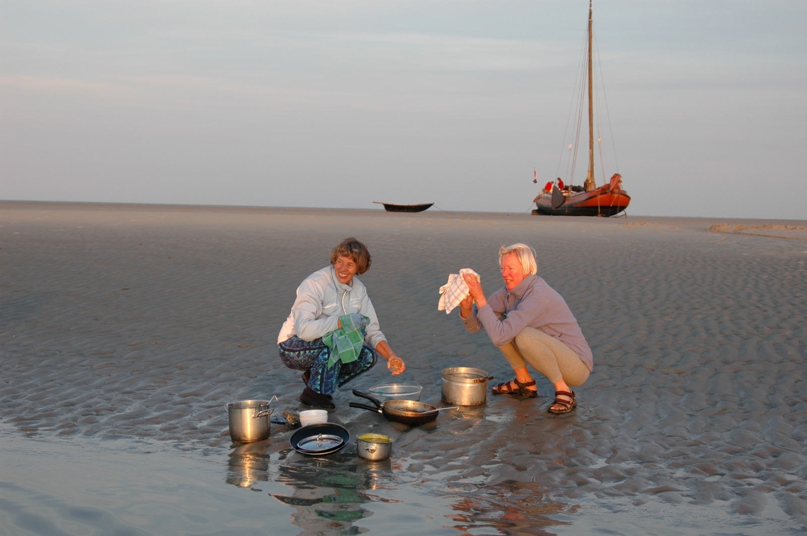 Na het eten afwassen, simpelweg in en mét zeewater dat – niet voor de kniesoor – zonder zeep alles met zand en de borstel prima schoon krijgt.